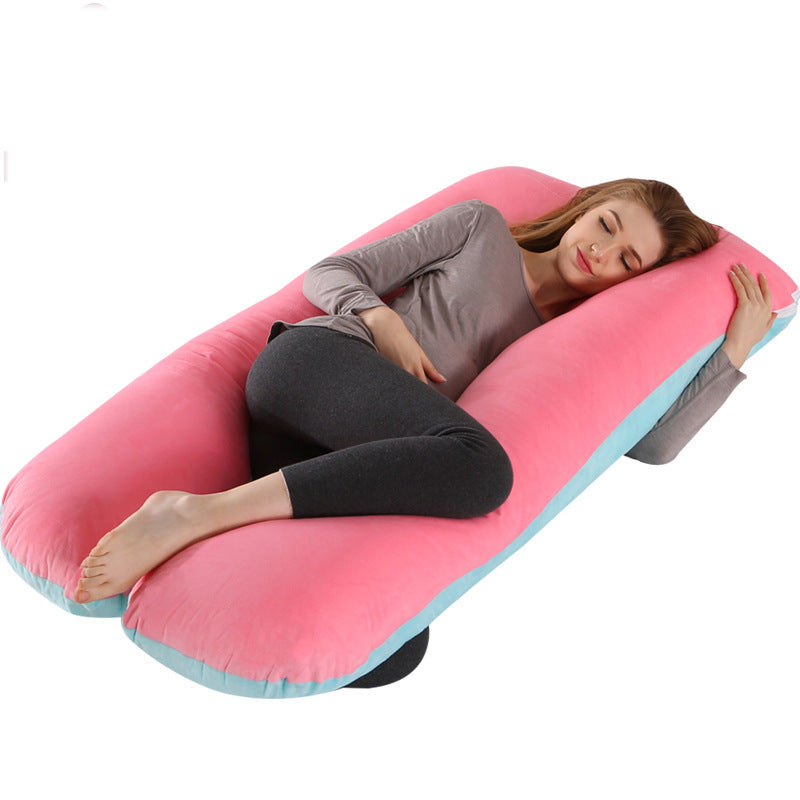 Woman lying on a pink U-shaped body pillow with a white background