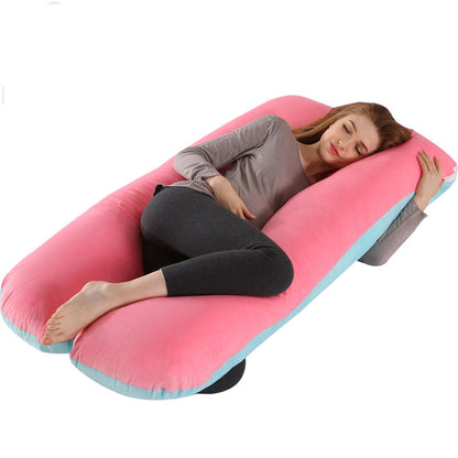 Woman lying on a pink U-shaped body pillow with a white background